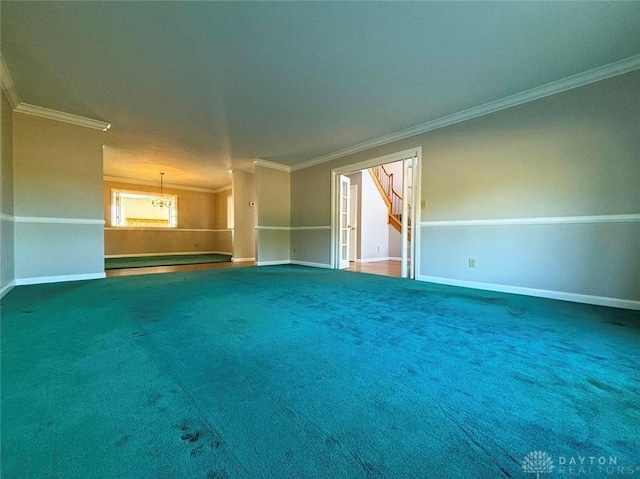 unfurnished room featuring ornamental molding, carpet, baseboards, and an inviting chandelier