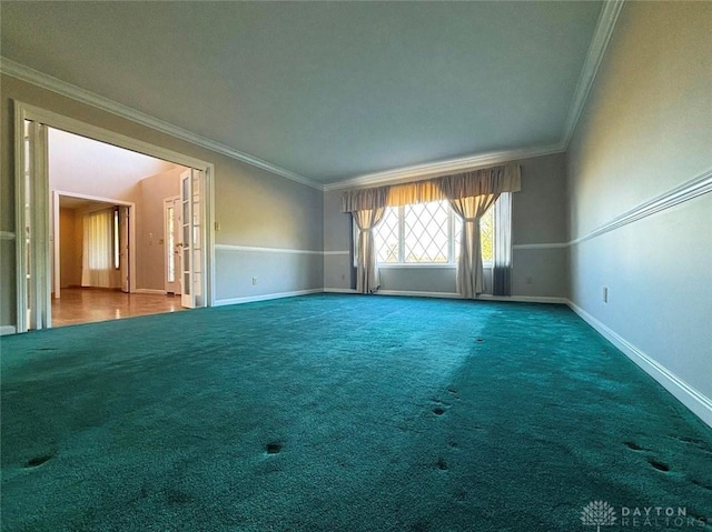 carpeted empty room featuring baseboards and crown molding