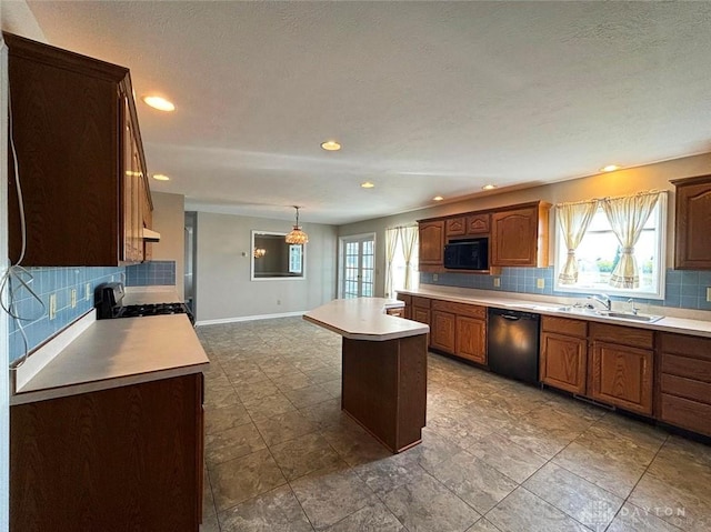 kitchen with baseboards, a center island, light countertops, black appliances, and a sink