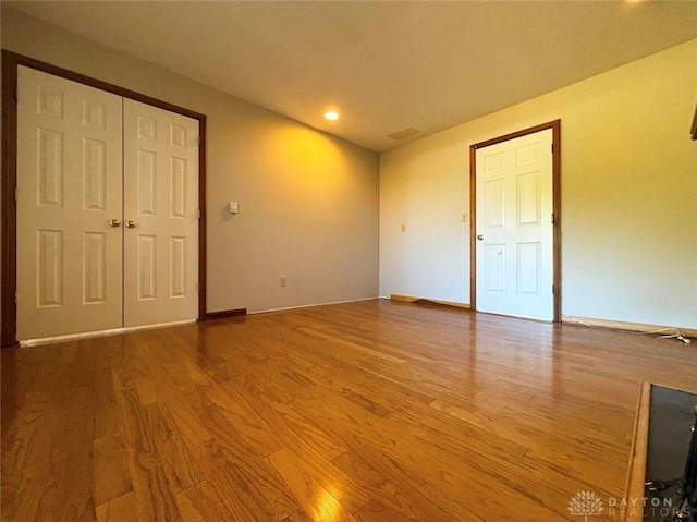 unfurnished bedroom featuring a closet, baseboards, and wood finished floors