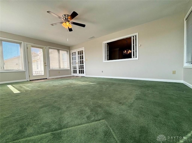 carpeted empty room featuring visible vents, a ceiling fan, and baseboards