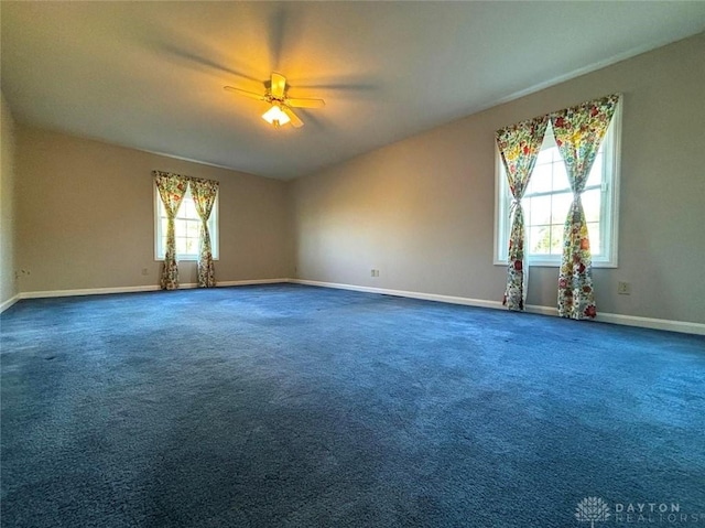 spare room with carpet floors, a ceiling fan, and baseboards