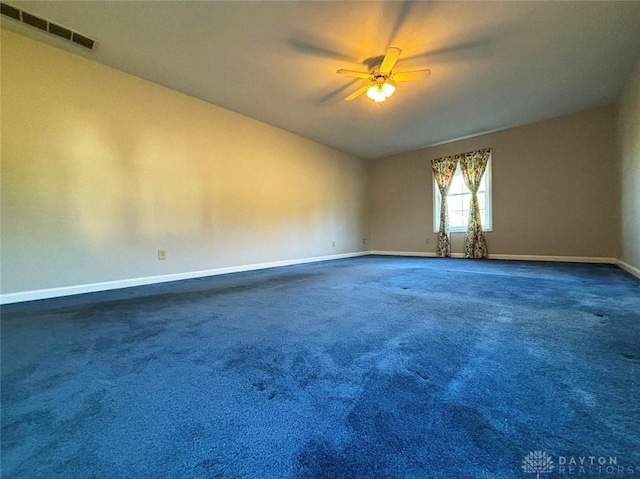 carpeted empty room with baseboards, visible vents, and ceiling fan