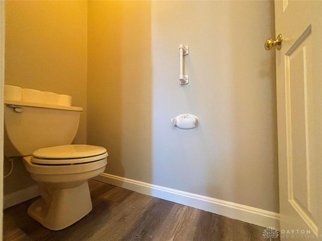 bathroom with toilet, baseboards, and wood finished floors