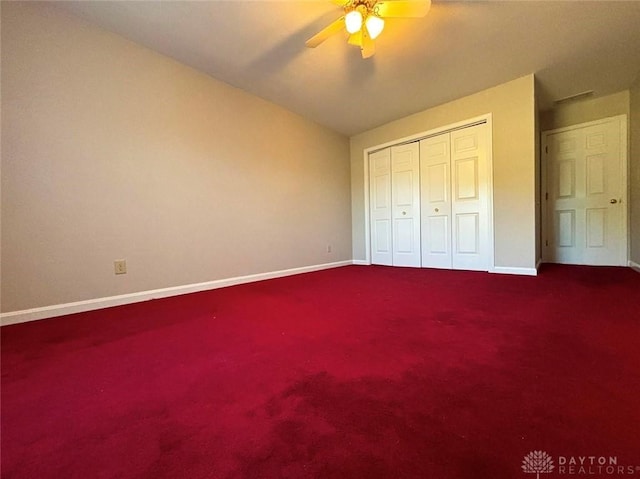 unfurnished bedroom with carpet floors, a closet, baseboards, and a ceiling fan