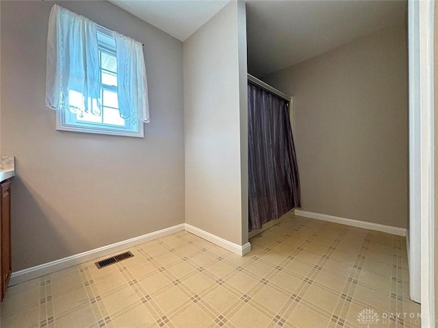 interior space featuring visible vents, baseboards, a shower with curtain, tile patterned floors, and vanity