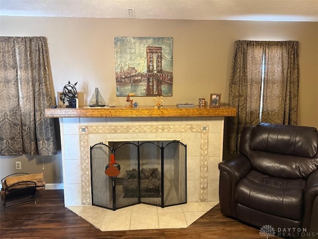 interior space featuring a tiled fireplace and wood finished floors