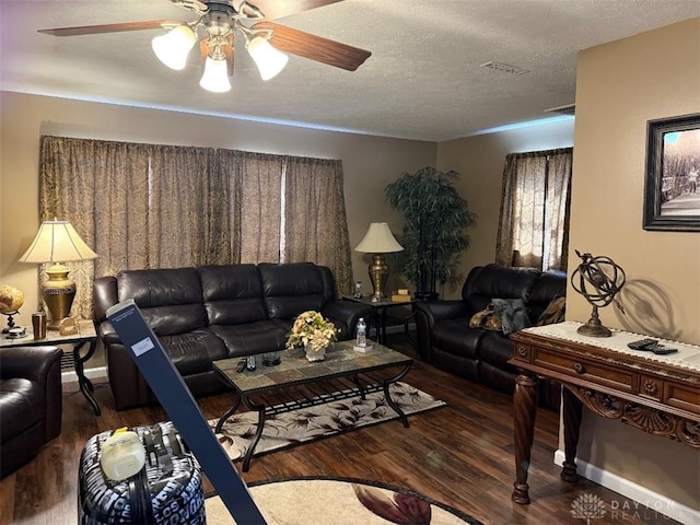 living room with visible vents, a textured ceiling, a ceiling fan, and wood finished floors