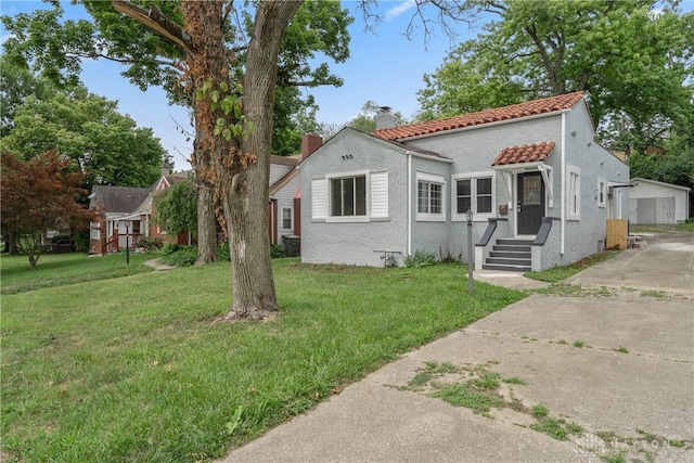 view of front facade with a chimney, a front lawn, and stucco siding