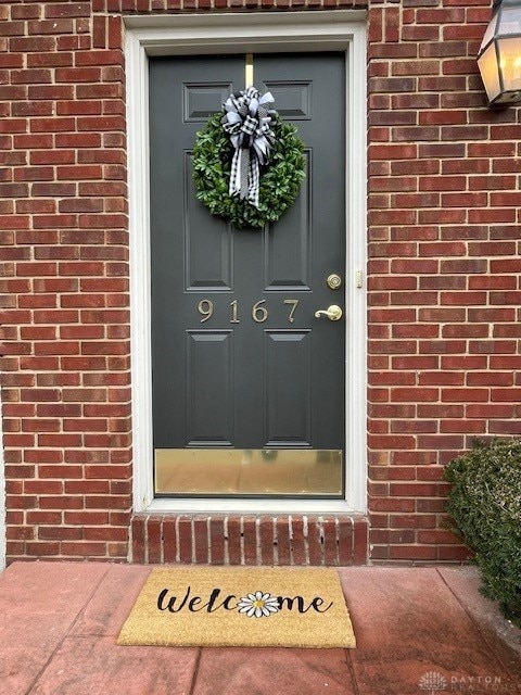 view of exterior entry featuring brick siding