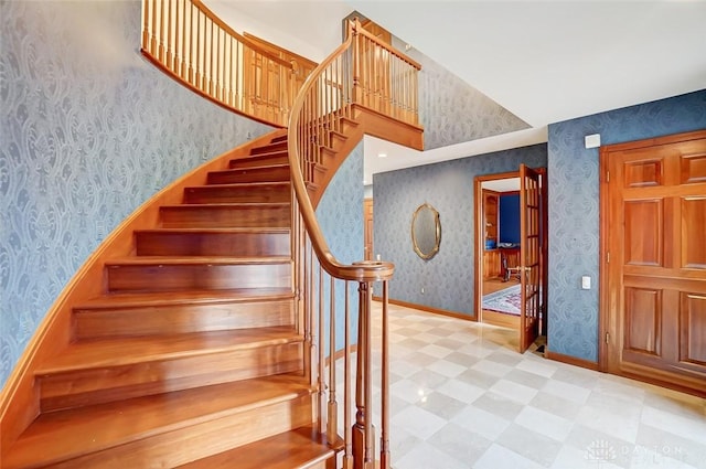 staircase with wallpapered walls, baseboards, and tile patterned floors