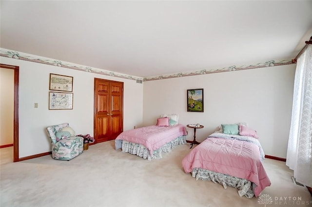 carpeted bedroom with a closet and baseboards