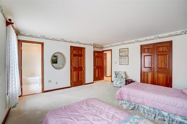 bedroom featuring ensuite bath, carpet, and baseboards