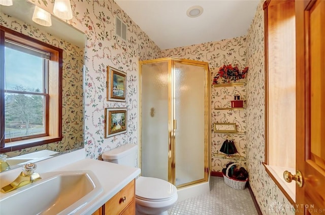 bathroom with toilet, a shower stall, vanity, tile patterned flooring, and wallpapered walls