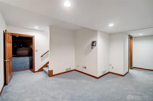 finished below grade area with visible vents, stairs, baseboards, and recessed lighting