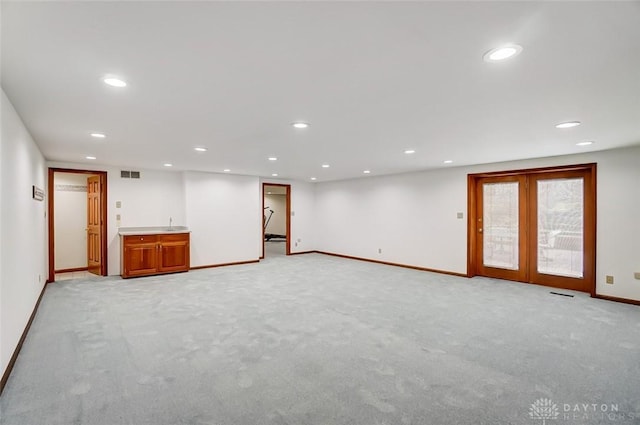 empty room featuring recessed lighting, light carpet, visible vents, baseboards, and french doors