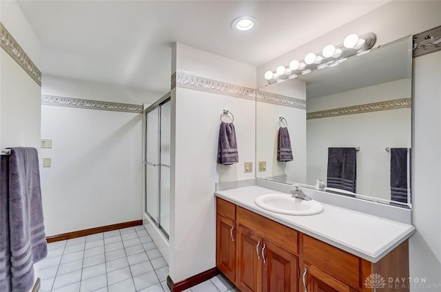 bathroom with baseboards, vanity, a shower stall, and tile patterned floors