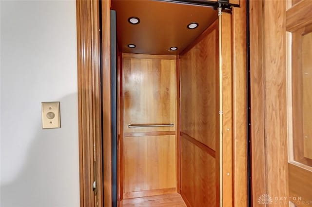 room details featuring elevator, wood finished floors, and recessed lighting