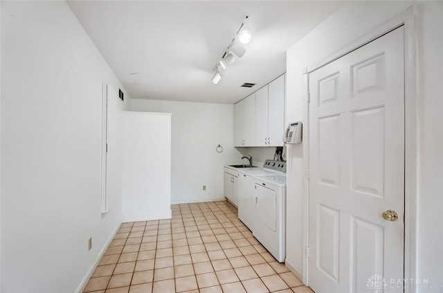 washroom featuring light tile patterned flooring, a sink, independent washer and dryer, cabinet space, and rail lighting