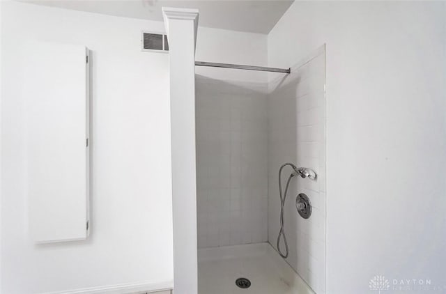 bathroom with a tile shower and visible vents