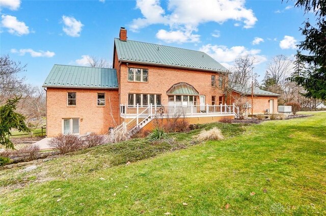 6485 Munger Rd, Dayton, OH 45459 - back of house featuring a standing seam roof, metal roof, stairs, a lawn, and a chimney