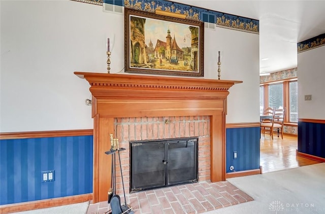 details featuring carpet floors, a wainscoted wall, visible vents, and a fireplace