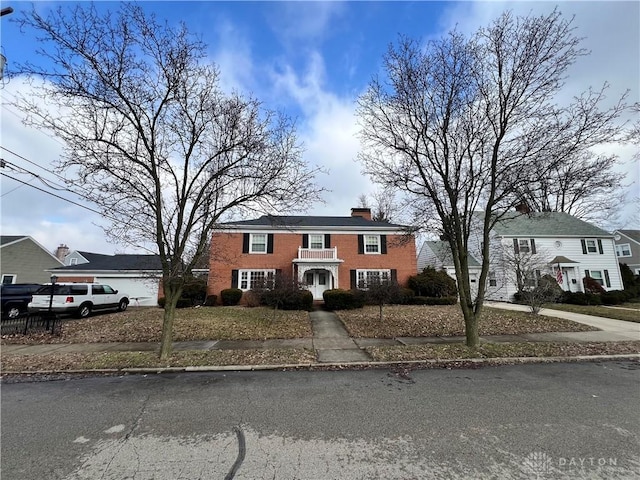 view of front of home with a chimney and brick siding