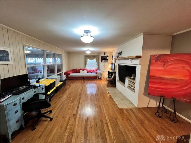 bedroom with ornamental molding, a fireplace with flush hearth, and wood finished floors