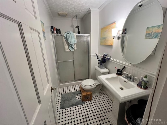 full bathroom featuring toilet, a stall shower, and crown molding