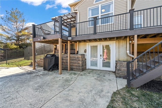 rear view of property with french doors, a patio, fence, a wooden deck, and stairs