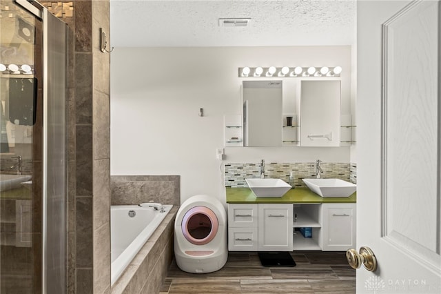 full bath featuring a garden tub, tasteful backsplash, a sink, and a shower stall