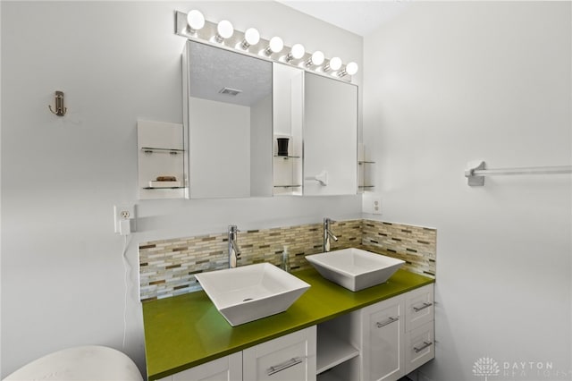 full bathroom featuring tasteful backsplash, visible vents, a sink, and double vanity