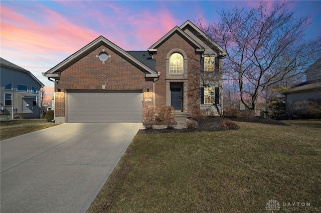 traditional-style home featuring an attached garage, a yard, concrete driveway, and brick siding