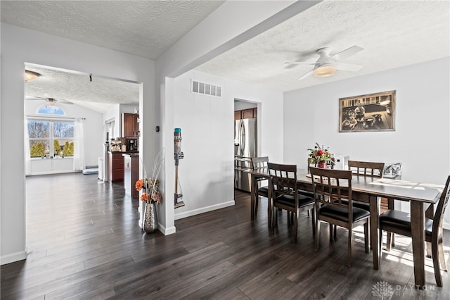 dining area with ceiling fan, visible vents, dark wood finished floors, and a textured ceiling