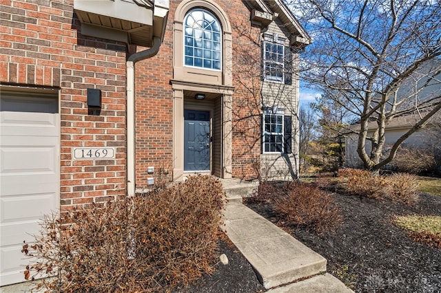 entrance to property with brick siding and an attached garage