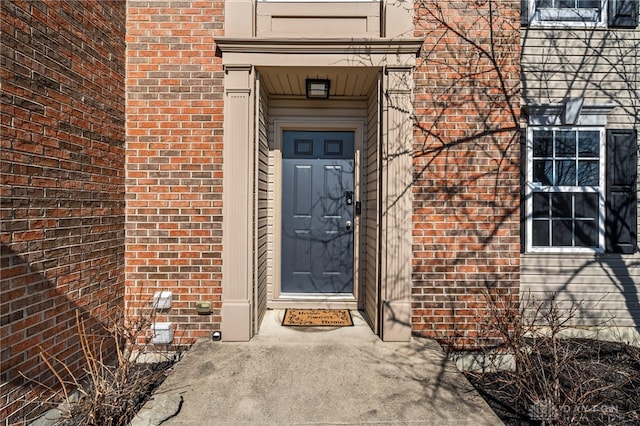 doorway to property featuring brick siding