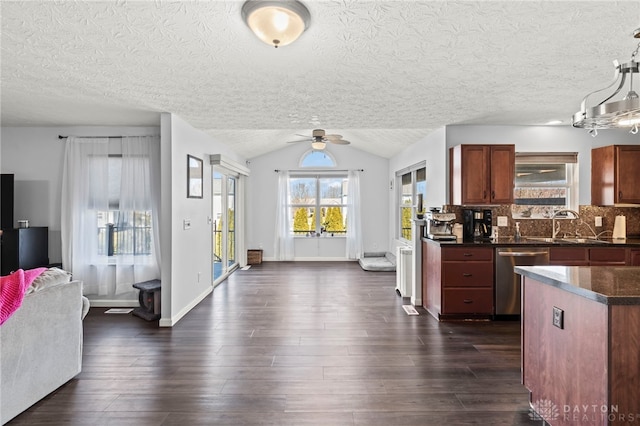 kitchen with tasteful backsplash, dark countertops, dark wood-style floors, open floor plan, and stainless steel dishwasher