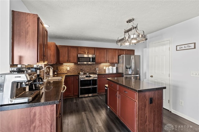 kitchen featuring a sink, appliances with stainless steel finishes, backsplash, and dark wood finished floors