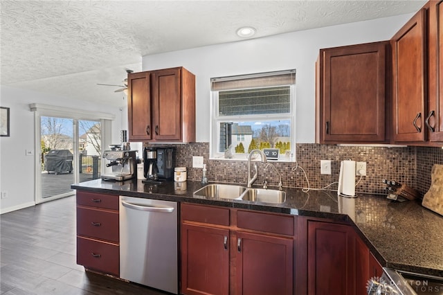 kitchen featuring decorative backsplash, stainless steel dishwasher, dark wood-type flooring, a ceiling fan, and a sink