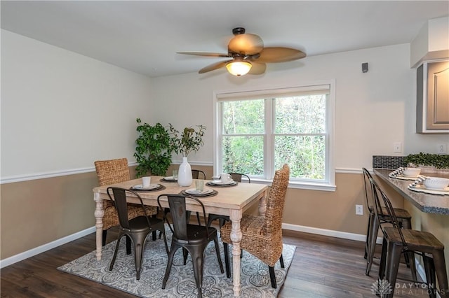 dining room with dark wood-type flooring, baseboards, and a ceiling fan