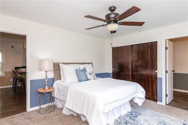 carpeted bedroom with ceiling fan, baseboards, and a closet