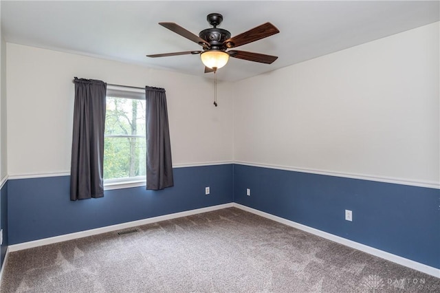 carpeted empty room featuring a ceiling fan, visible vents, and baseboards