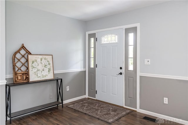 foyer entrance with visible vents, baseboards, and wood finished floors