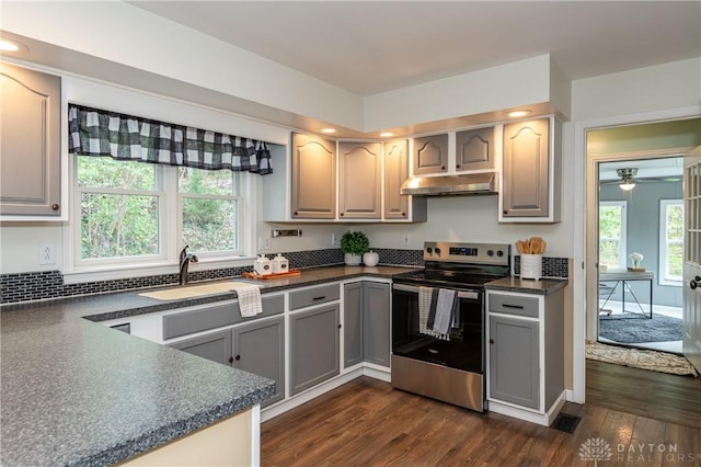 kitchen featuring dark countertops, gray cabinetry, stainless steel range with electric cooktop, a sink, and under cabinet range hood