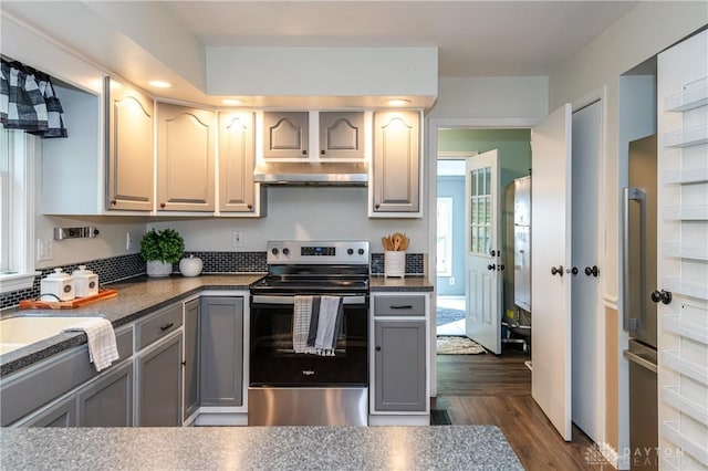 kitchen with electric range, dark countertops, gray cabinets, and under cabinet range hood