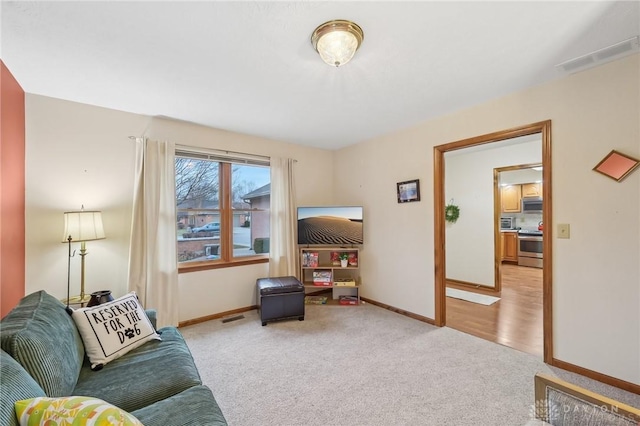 living area featuring visible vents, light carpet, and baseboards