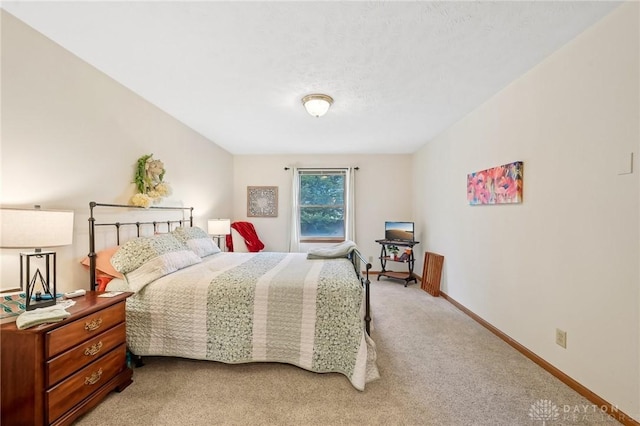 bedroom with baseboards and light colored carpet