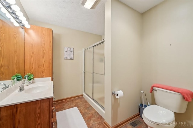 bathroom with visible vents, toilet, a shower stall, vanity, and baseboards