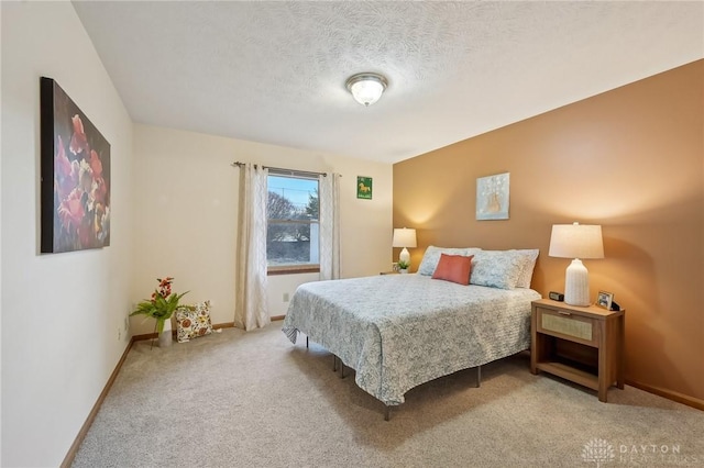 bedroom with carpet, a textured ceiling, and baseboards