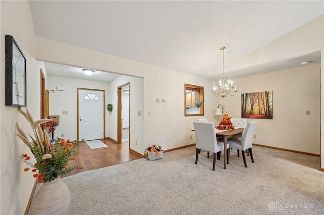 dining room featuring carpet flooring, a notable chandelier, and baseboards